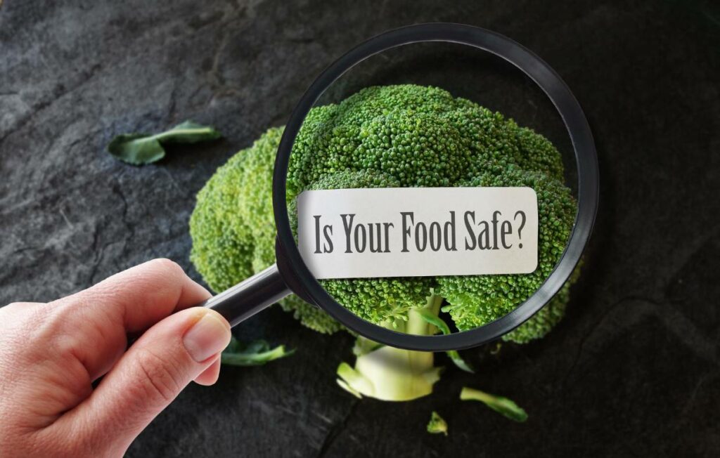 A broccoli with a magnifying glass and a sign that says "is your food safe"?
