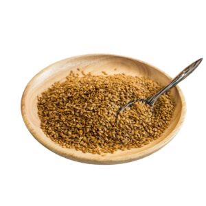 Golden flaxseeds on a wooden plate with a spoon.
