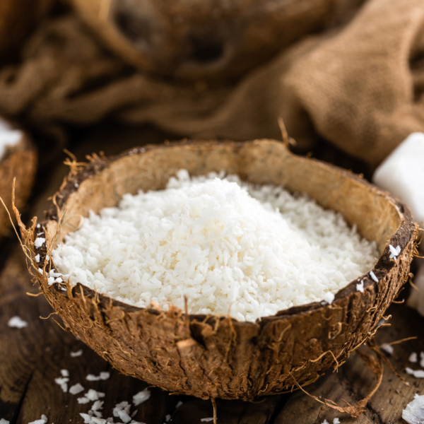 Medium sized coconut granules in a coconut shell used as a bowl.