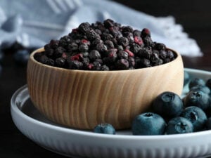 Cut Blueberries in a wooden bowl.