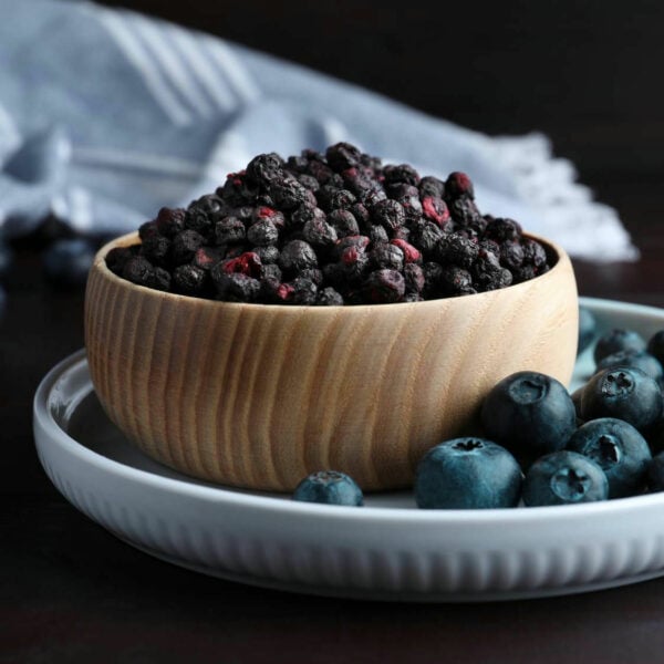 Cut Blueberries in a wooden bowl.