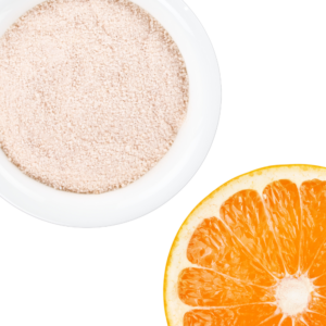 Orange powder in a white bowl displayed with half an orange.