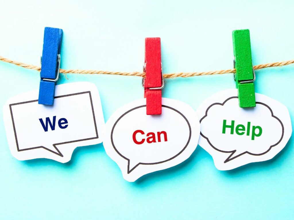 We can help concept speech bubbles hanging on clothes pegs on blue background with copy space