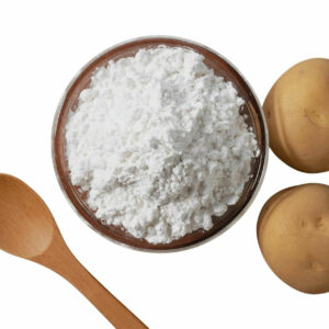 Top view of white powder in a bowl displayed with two potatoes and a wooden spoon.
