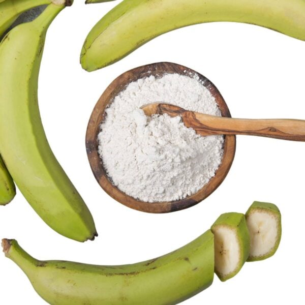 Top view of whitish powder in a bowl , surrounded by three , green bananas.