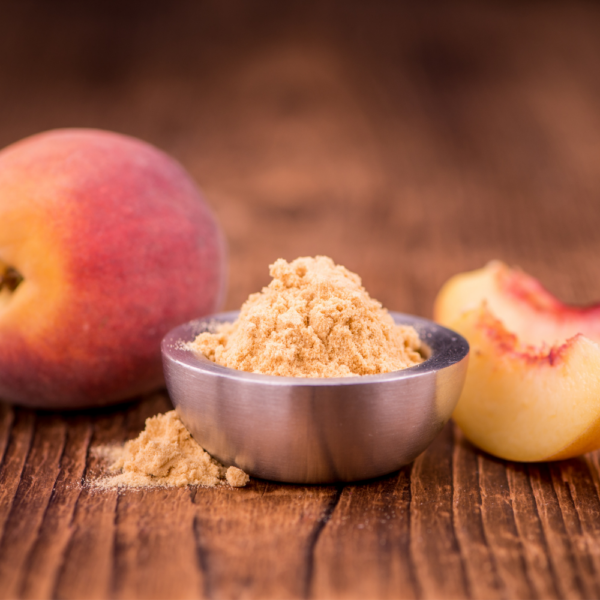 Peach fruit beside a bowl of orangish powder