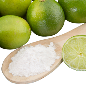 Wooden spoon with white powder displayed with whole lime fruits