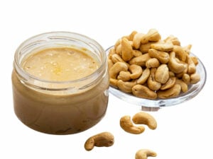 Cahew Butter in a jar beside some cashew nuts