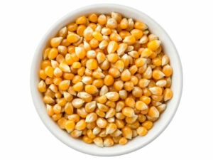 Top view of yellow popcorn grains in a bowl.