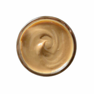 Top view of brown peanut paste in a jar.