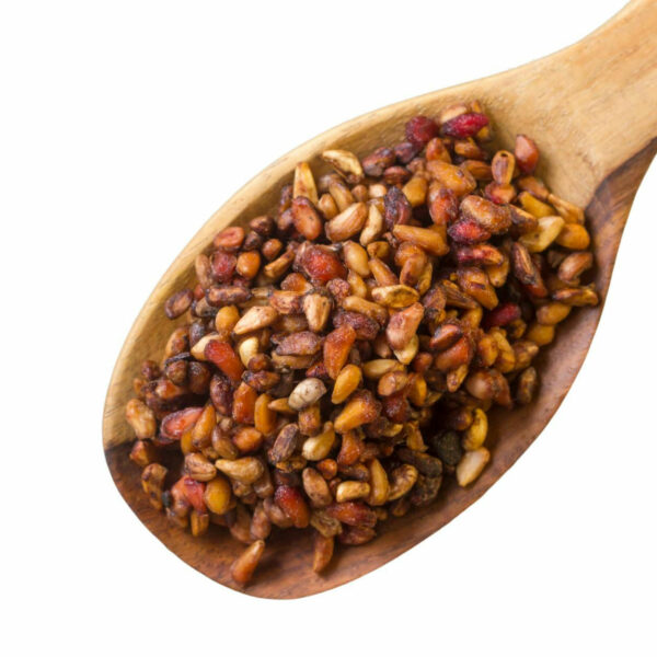 Dried pomogranate seeds on a wooden spoon.