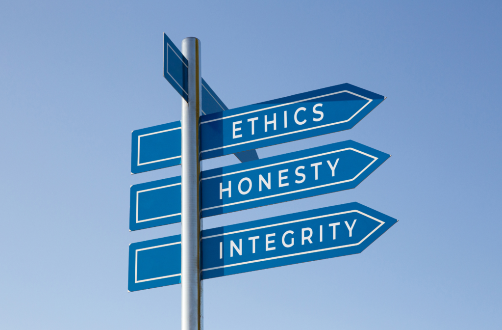 a street sign pointing to ethics, honesty and integrity