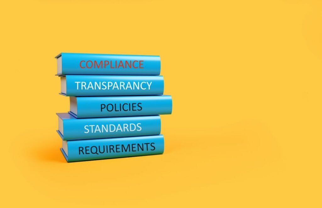 a stack of books with the words compliance, transparency, policies, and requirements