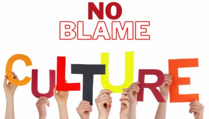 a group of hands holding up the word "no blame culture"