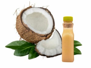 Bottle with a white substance beside an open coconut.