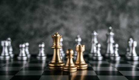 gold and silver chess pieces on a chess board