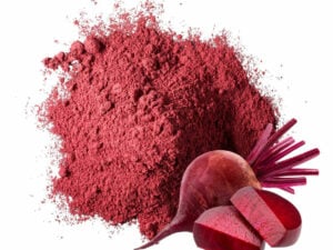 Top view of vibrant red-purple powder displayed with a beetroot.