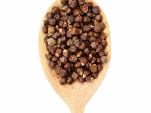 Top view of brown seeds displayed on a wooden spoon.