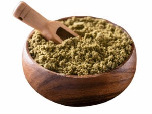 Green, dried, grasslike powder in a bowl.