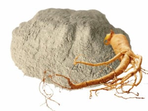 Grey powder in a heap dispayed with a ginseng root.