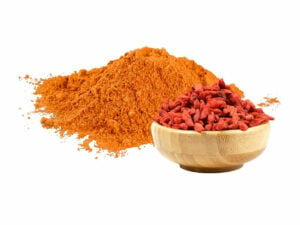 Red-orange powder beside a bowl of goji berries.
