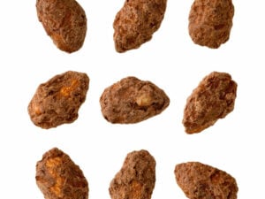 Nine almond nuts coated with brown powder, displayed in a grid.